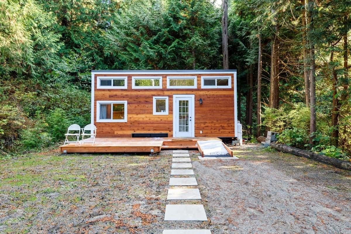 Tiny House im Wald mit Fentern und Weg zum Hause