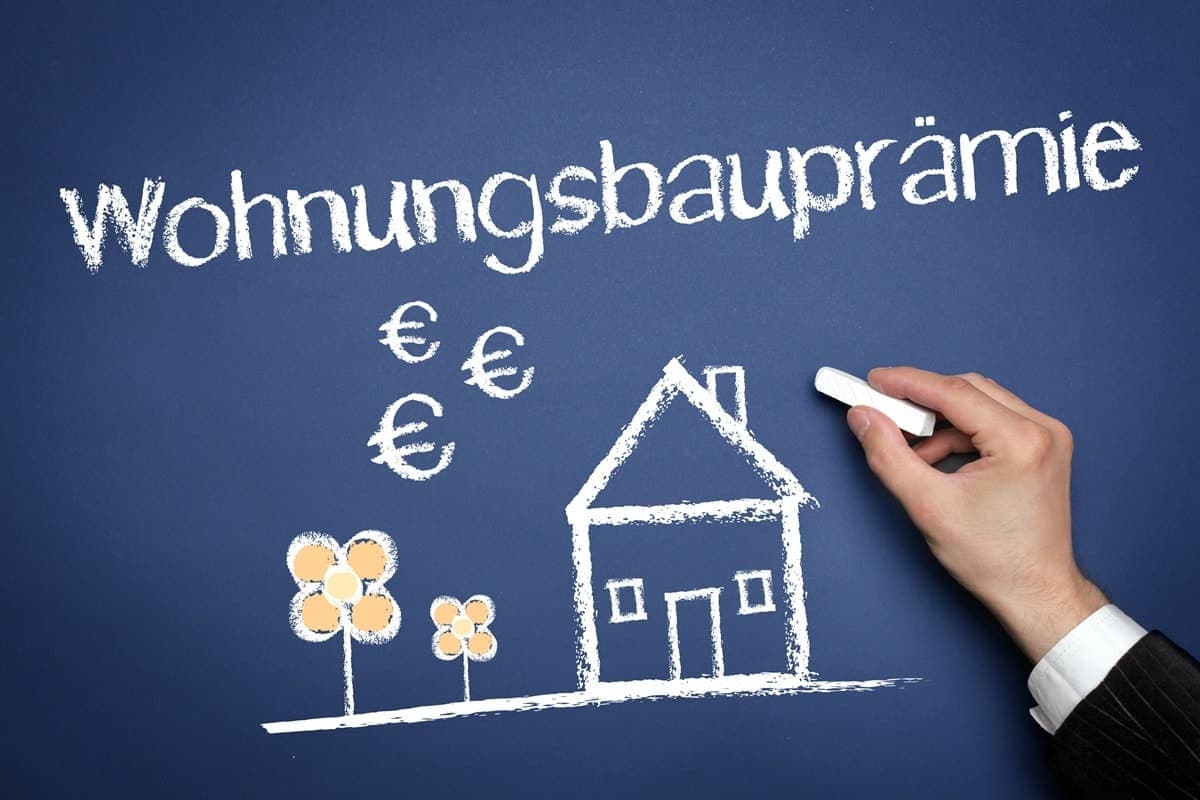 Tafel mit Aufschrift Wohnungsbauprämie und gezeichnetem Haus