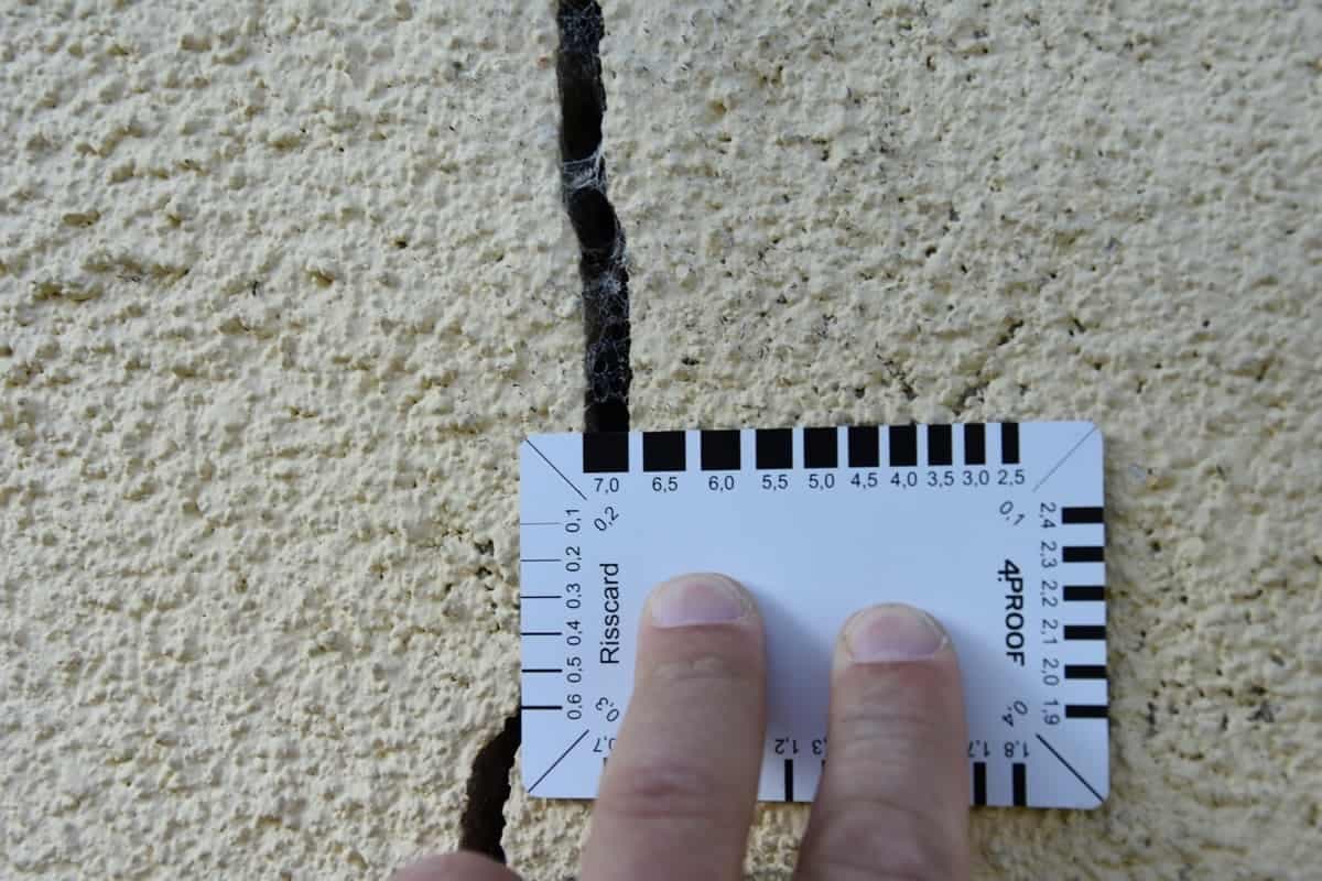 Ein Riss im Mauerwerk, 7 mm breit, mit Rissbreitenkarte gemessen