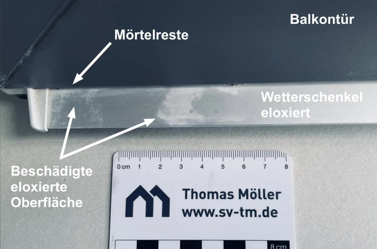 Ein eloxierter Aluminium-Wetterschenkel an einer Terrassentür. Der Schenkel hat Flecken und es sind Mörtelreste zu erkennen.