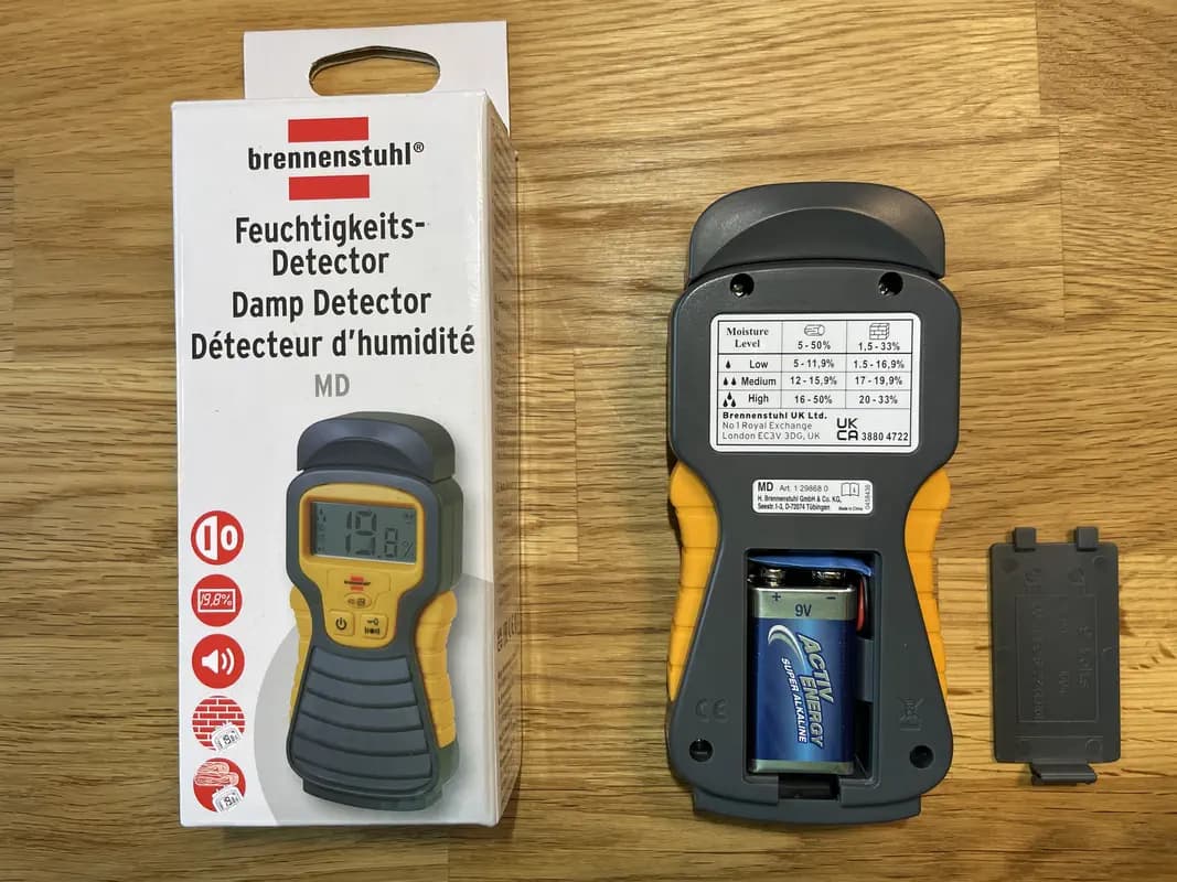 Das Holzfeuchtemessgerät Brennenstuhl Feuchtigkeits-Detector MD mit geöffnetem Batteriefach. Das Gerät wird mit einem 9-V-Block betrieben. Auf der Rückseite befindet sich eine praktische Feuchtigkeitsübersicht.