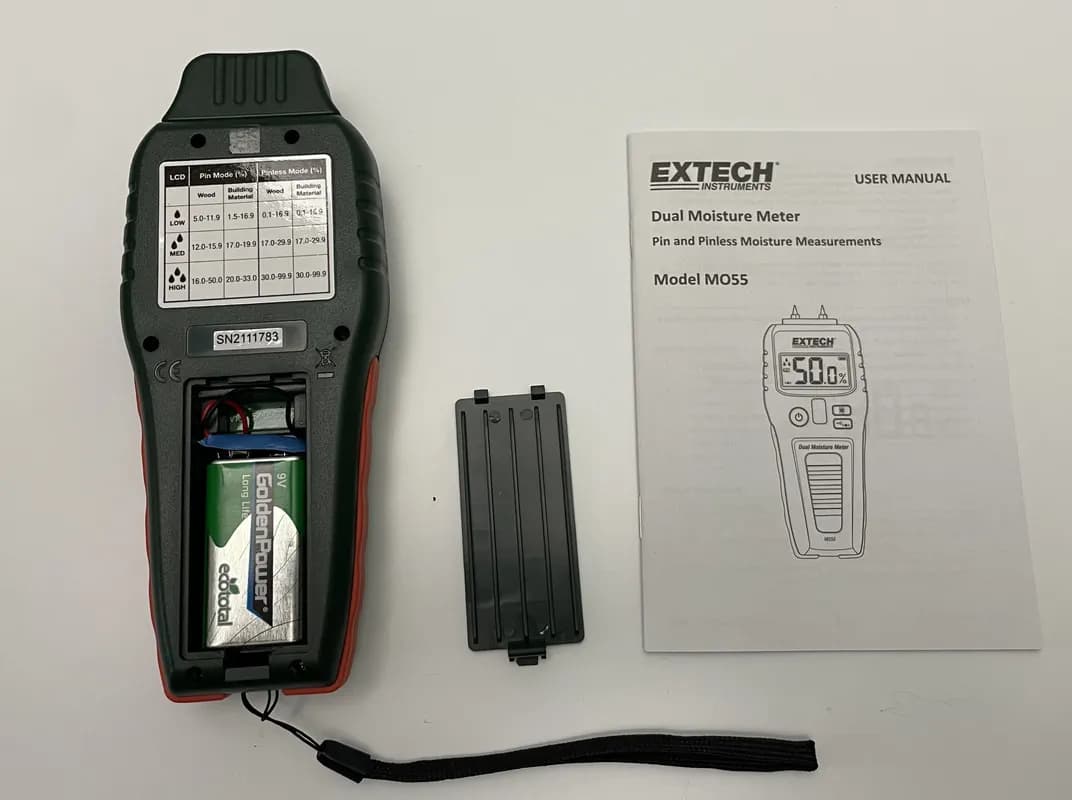 Das EXTECH MO55 liegt mit aufgeschraubtem Batteriefach auf dem Tisch.