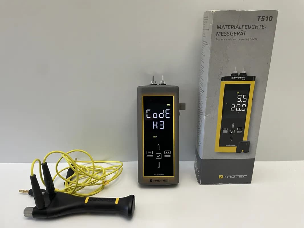 Das Holzfeuchtemessgerät TROTEC T510 mit Verpackung und Handelektrode im Test.