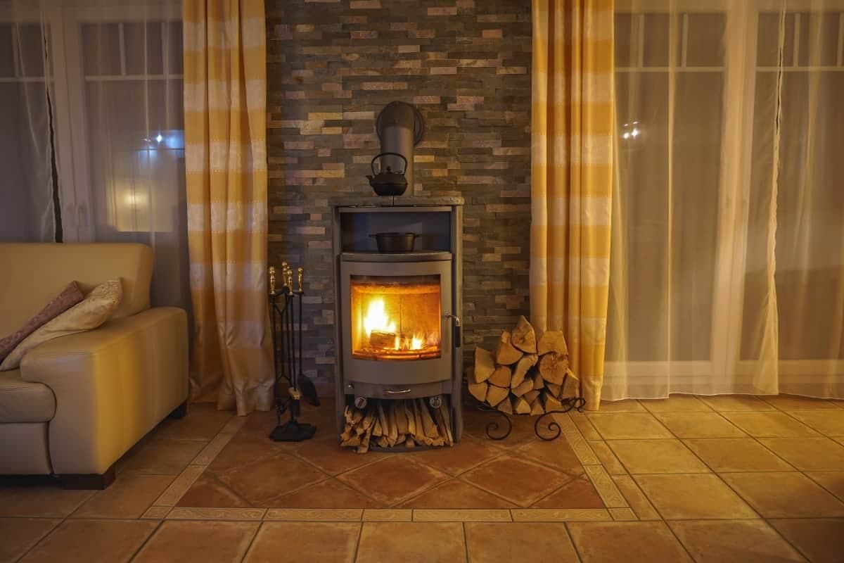 Brennender Kaminofen im Wohnzimmer - Gemütliche Stunden vor dem Kamin sind gerade in der kalten Jahreszeit sehr reizvoll.
