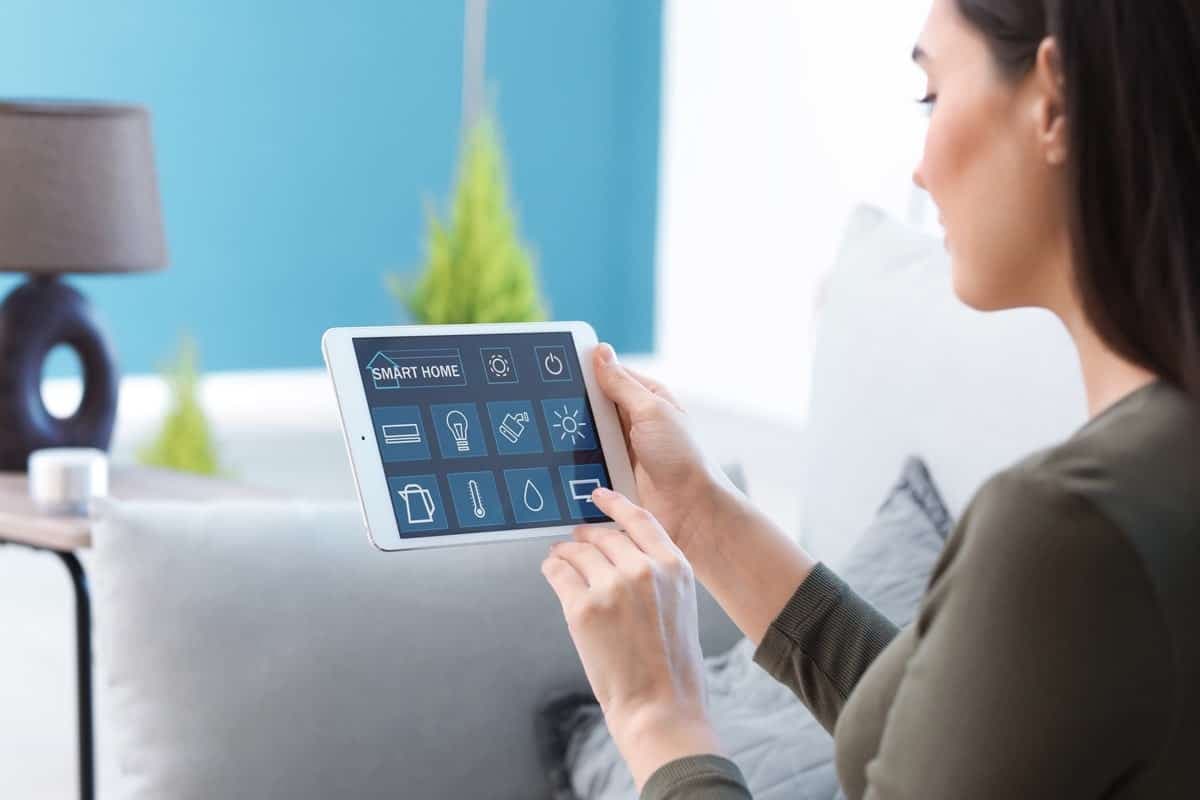 Junge Frau verwendet eine Tablet für ihr Smart-Home-Steuerung