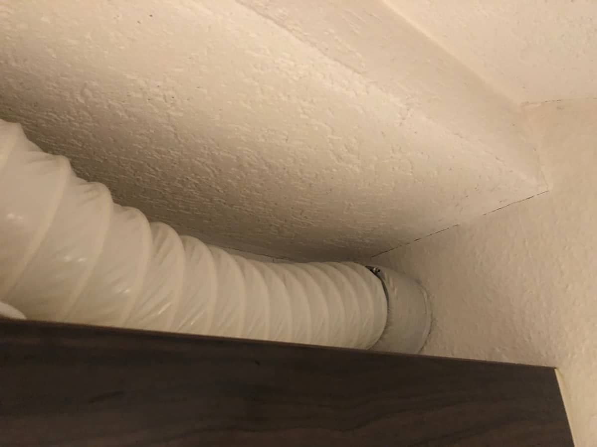 Abluft einer Dunstabzugshaube nach draußen über einem Küchenschrank