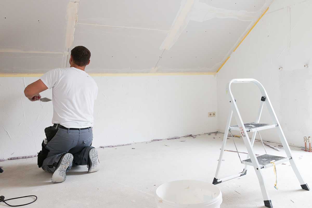 Trockenbauer spachtelt Wand