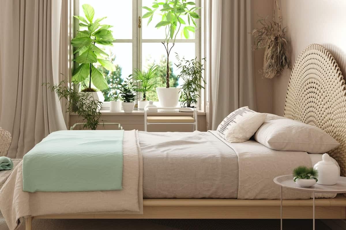 Schlafzimmer mit großem Fenster, Pflanzen und Blick ins Grüne