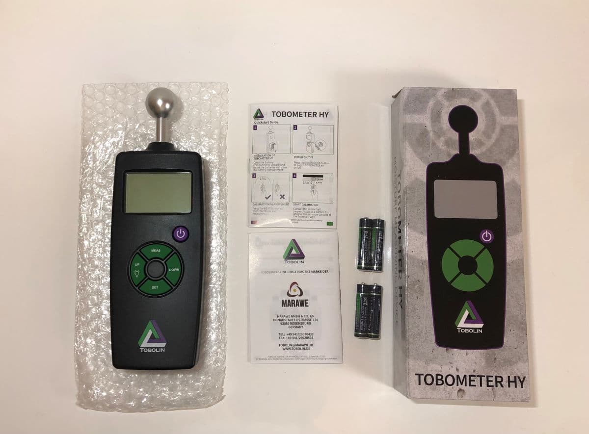 Das TOBOMETER HY Feuchtigkeitsmessgerät mit Verpackung, Anleitung und 4 AAA-Batterien im Test