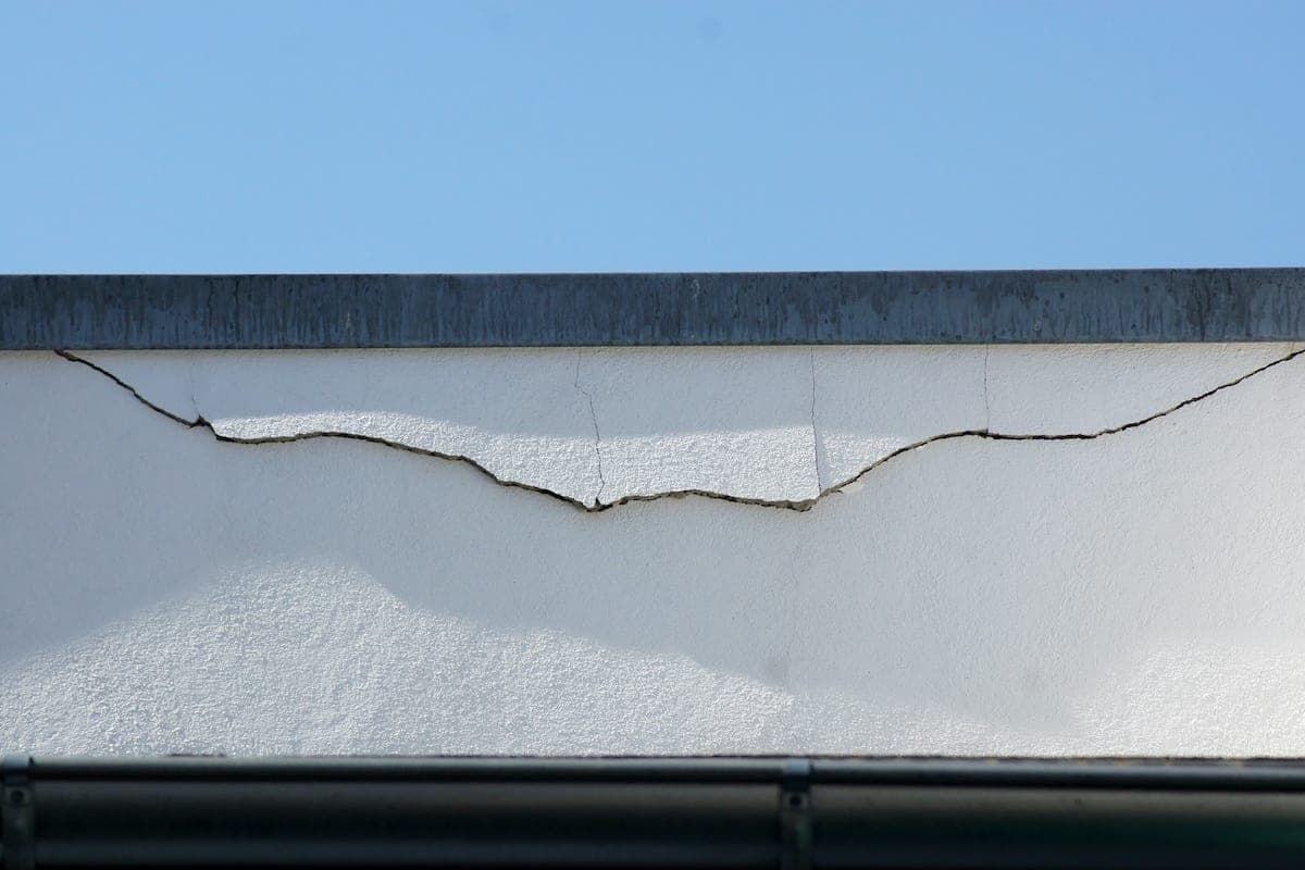 Ein breiter Putzriss in der Fassade unter der Attika