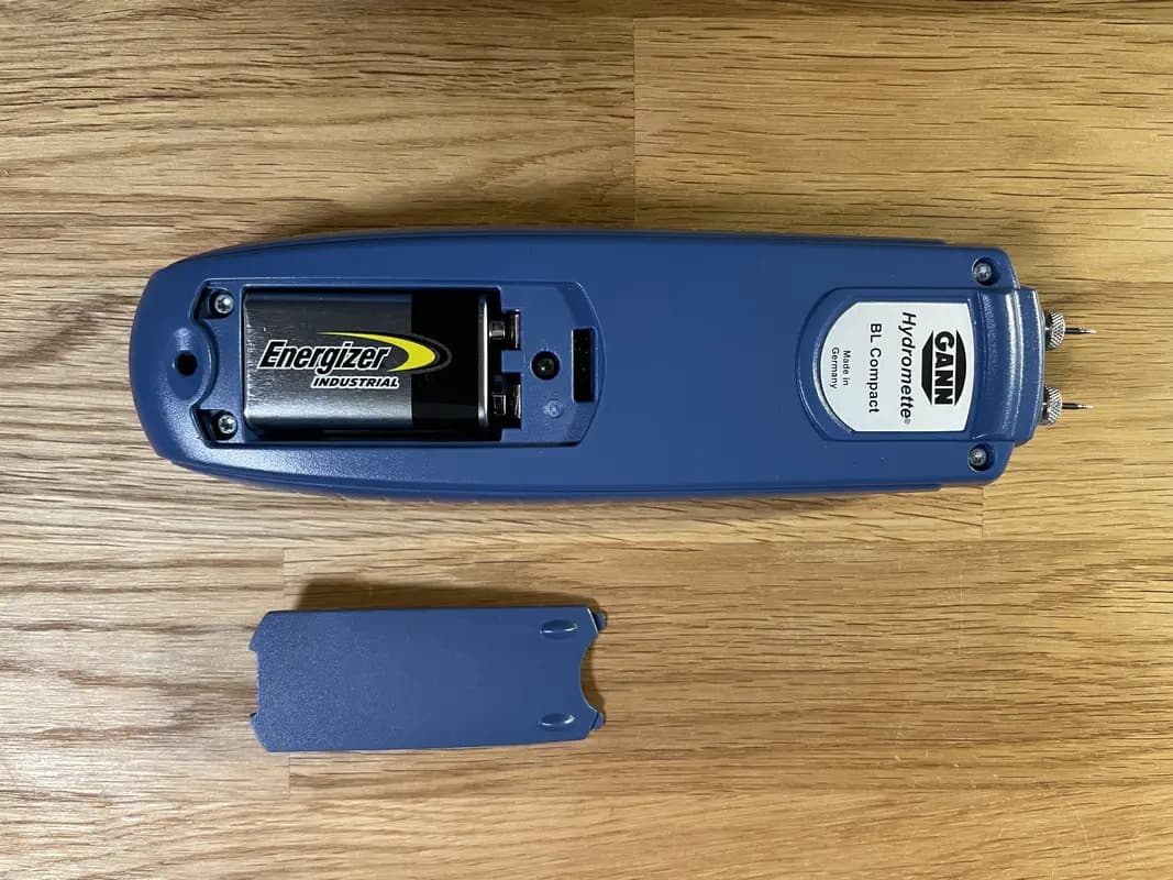Das Holzfeuchtemessgerät GANN Hydromette BL Compact mit geöffnetem Batteriefach, in dem ein 9 V Block zu sehen ist.