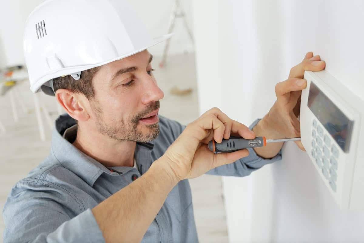 Ein Installateur befestigt die Steuerung für die Heizung