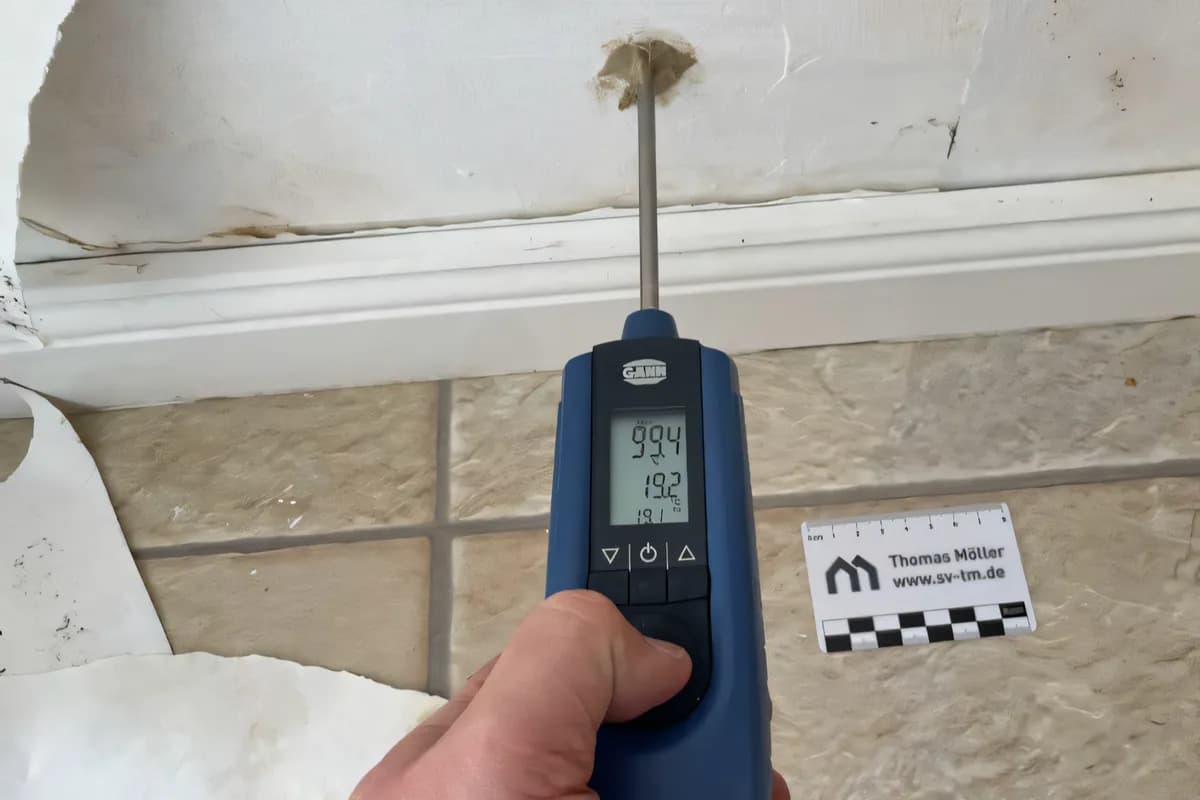 Das Messgerät GANN Hydromette RH-T bei der hygrometrischen Feuchtemessung Messung in einem Bohrloch. Man sieht die Wand die mit Bohrloch, die Sockelleiste und Fliesen.
