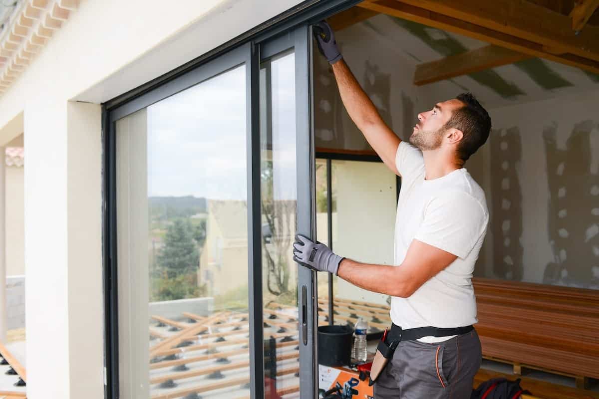 Ein Handwerker überprüft Fenster und Türen eines Neubaus